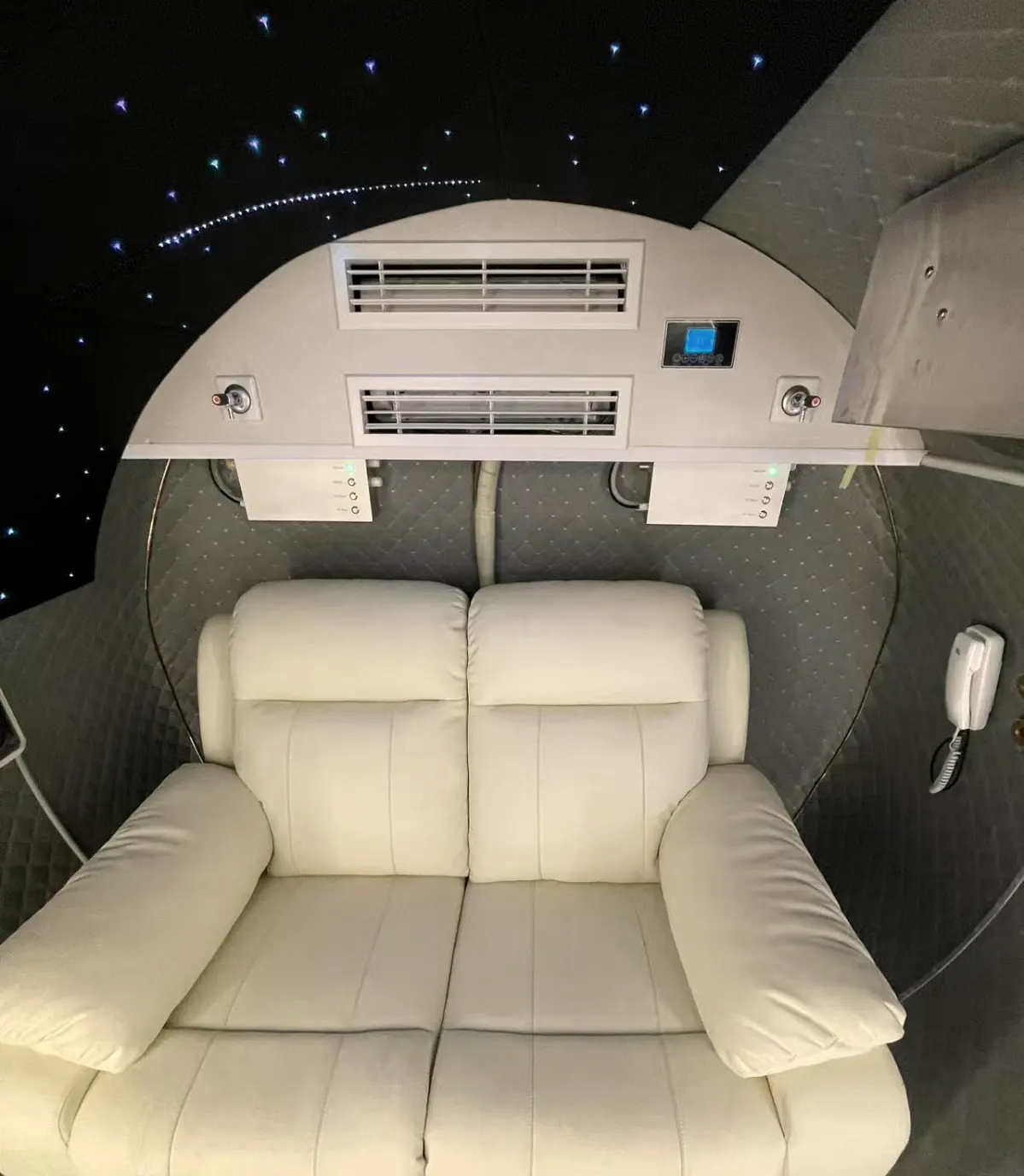 Two-seat ivory leather sofa under a starlight ceiling, with ceiling air-conditioning vents and intercom